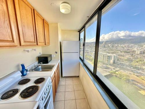 a kitchen with a sink and a refrigerator and a window at Ocean Canal Mountain View Steps from Waikiki Beach 6person in Honolulu
