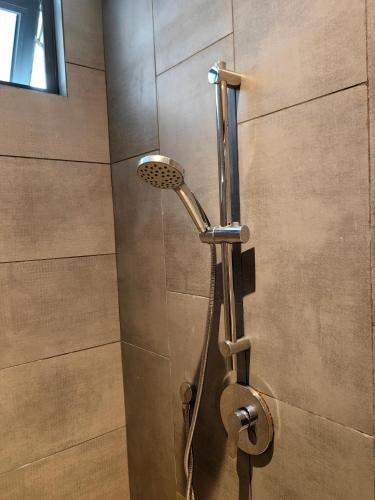 a shower with a shower head in a bathroom at Near Airport K Avenue Family Room in Donggongon