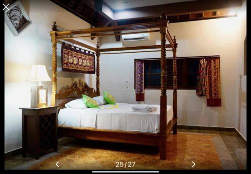 a bedroom with a canopy bed in a room at Royen Balinese Family Guest House- Traditional Batuan Homestay in Sukawati