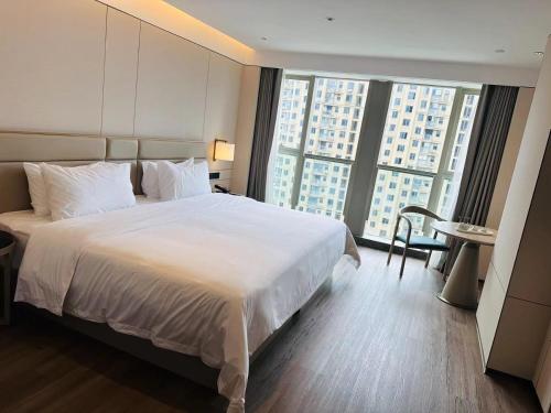Ένα ή περισσότερα κρεβάτια σε δωμάτιο στο Manju Hotel Shaoxing Keqiao Wanda