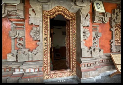 an ornate mirror on the side of a building at Royen Balinese Family Guest House- Traditional Batuan Homestay in Sukawati