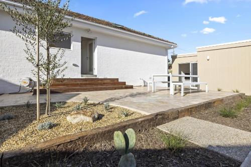 un patio con tavolo e panca di fronte a una casa di The Village Belle - Stay In The Heart of Sorrento a Sorrento