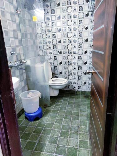 a bathroom with a toilet and a sink and a door at Cloud 7 in Nainital