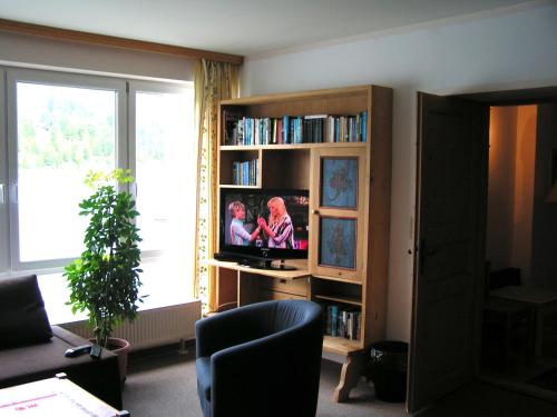 salon z telewizorem w półce na książki w obiekcie Bauernstubn w mieście Turracher Hohe