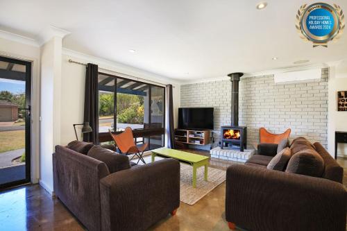 a living room with two couches and a fireplace at Aloha - Short Drive to Berry & The Beach - Fireplace and Firepit in Shoalhaven Heads