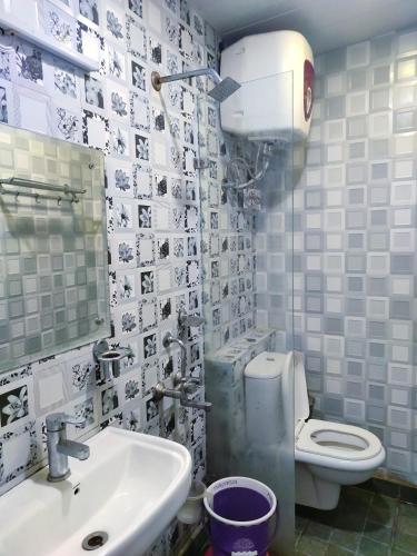 a bathroom with a toilet and a sink and a mirror at Cloud 7 in Nainital