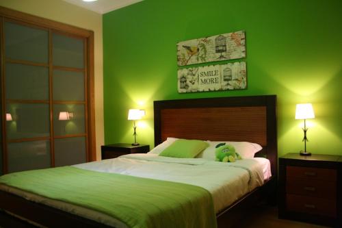 a green bedroom with a bed with a stuffed animal on it at Villa dos Teixos in Cascais