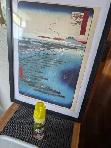 a bottle sitting on a mat in front of a picture at private rooms in togo beach and park side house in Numazu