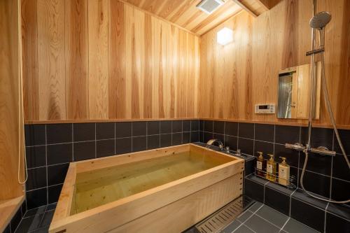 a wooden tub in a bathroom with wooden walls at RESI STAY Palace Gate in Kyoto