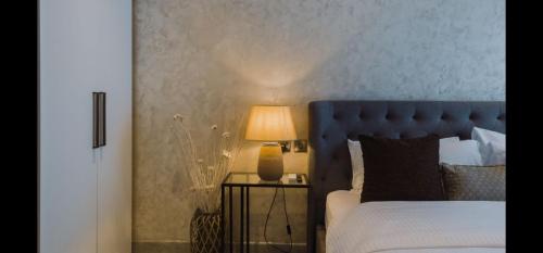 a bedroom with a bed and a lamp on a table at The Signature Hotel Apartment Accra Ghana in Accra