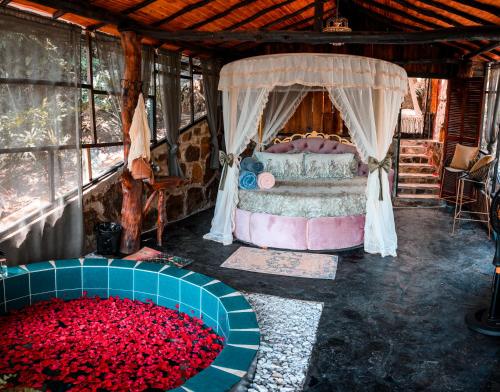 a bedroom with a bed and a tub of red roses at The Luxury Glamping Star in San Gil