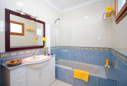 łazienka z wanną, umywalką i lustrem w obiekcie Grand Villa Famara Puerto del Carmen w Puerto del Carmen