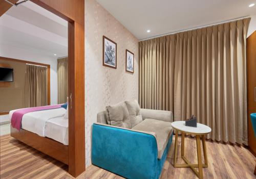 a bedroom with a bed and a chair and a table at Q-White Crescent in Cochin