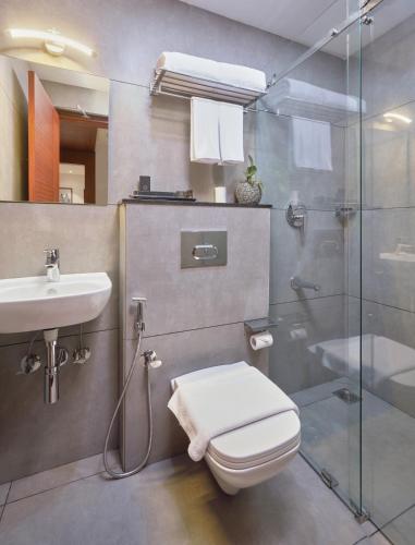 a bathroom with a toilet and a sink and a shower at Q-White Crescent in Cochin