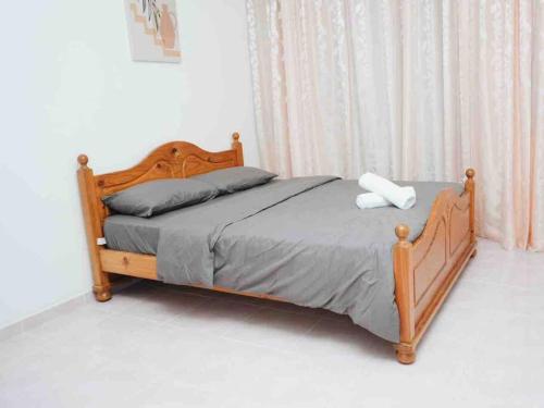a bed in a bedroom with a wooden frame at Trio homestay Bandar Kuala Terengganu in Kuala Terengganu