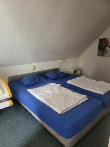 two beds in a room with blue and white sheets at Sleepspot Wedde in Wedde
