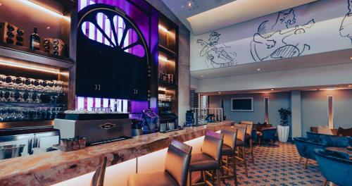 a bar in a restaurant with purple lighting at Piazza Hotel Montecasino in Johannesburg