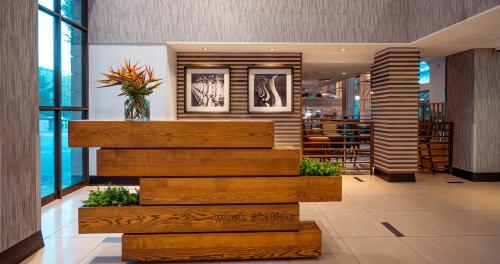a lobby with stairs and a vase of flowers at Piazza Hotel Montecasino in Johannesburg