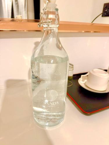 a bottle of water on a table with a plate at Sands Garden Hotel in Thoddoo