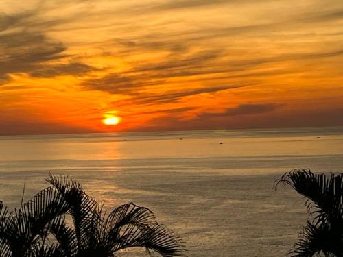 a sunset over the ocean with the sun setting at 海闊天空 丁一的家民宿 Pacific Ocean View in Chenggong