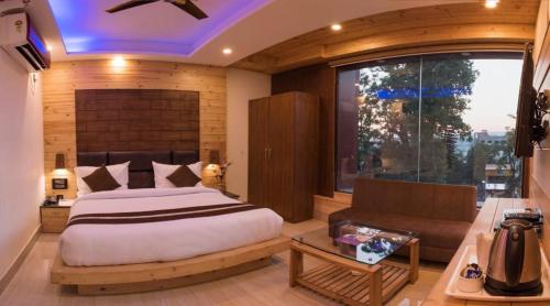 a bedroom with a bed and a couch and a window at Hotel Skyking in Dehradun