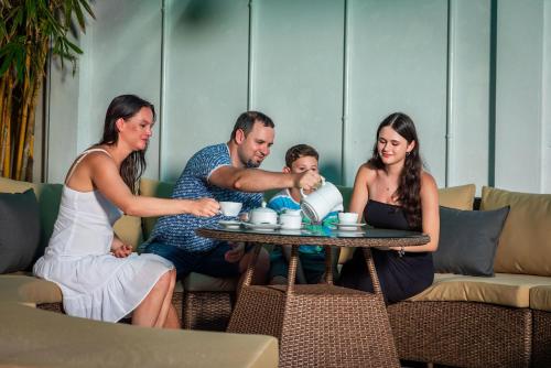 a group of people sitting around a table with a baby at The Palace by Ocean in Bentota