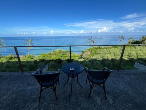a table and two chairs on a balcony with the ocean at 海闊天空 丁一的家民宿 Pacific Ocean View in Chenggong