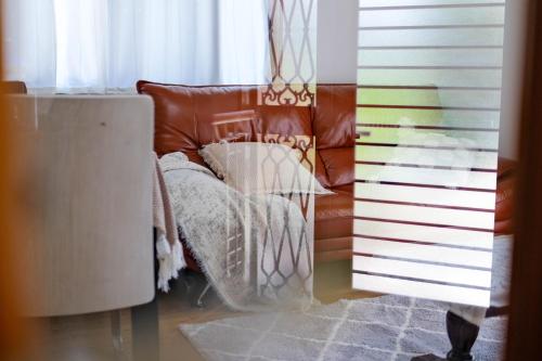 a brown leather couch sitting next to a window at HOEI villas Fujisan全景 富士山 河口湖中心区 in Fujikawaguchiko