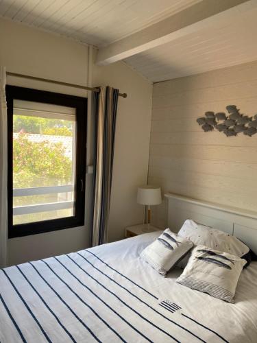 - une chambre avec un lit avec deux oreillers et une fenêtre dans l'établissement Villa avec piscine au bassin d'Arcachon, à Gujan-Mestras