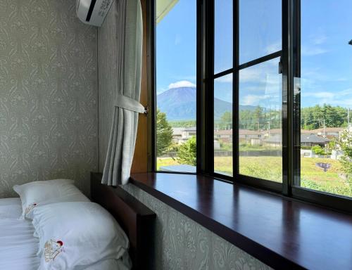 a bed in a room with a large window at HOEI villas Fujisan全景 富士山 河口湖中心区 in Fujikawaguchiko