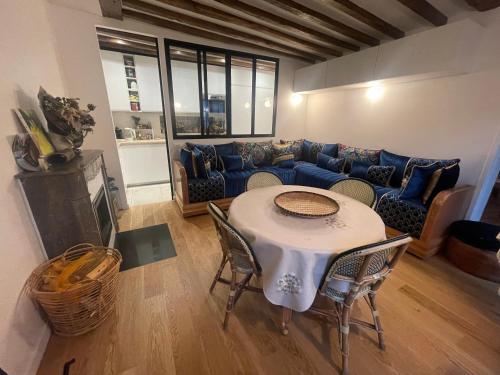 un salon avec un canapé bleu, une table et des chaises dans l'établissement APPAREMMENT Familiale Centre Paris 3ch 3SDB, à Paris