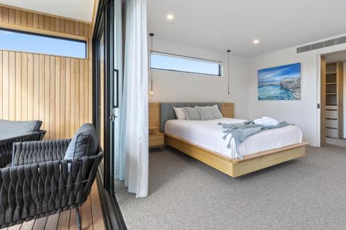 a bedroom with a bed and a chair at Cambridge Gardens - Sorrento Luxury with Gas Heated Spa, Solar Heated Pool in Sorrento