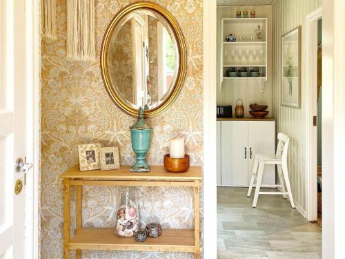 a room with a mirror and a table with a vase at 4 star holiday home in Edsbruk in Edsbruk