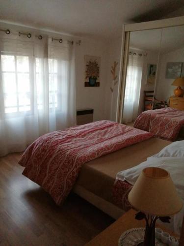 une chambre avec deux lits et une table avec une lampe dans l'établissement Gite lefevre a callian, à Callian