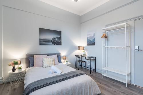 a bedroom with a large bed and a table at Tranquil Double Room - Next to Bus Station & Park & Chinatown - Shared Bathroom in Sydney