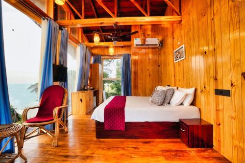 a bedroom with a bed and a chair and a window at SUN VIEW Beach Resort in Varkala