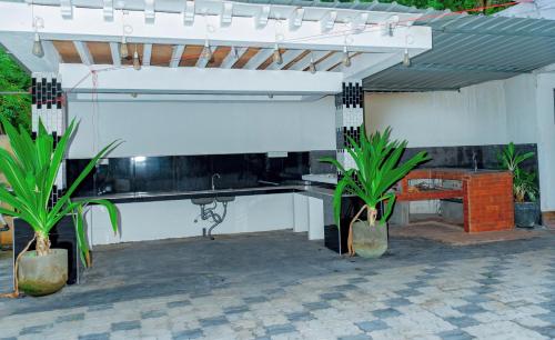 a pavilion with a bench and plants in a patio at Villa Exora Pasikudha in Batticaloa