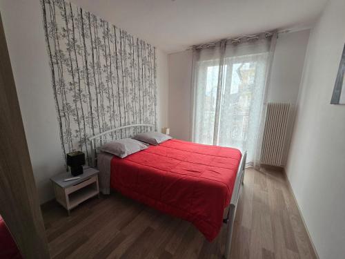- une chambre avec un lit rouge et une fenêtre dans l'établissement Bel appartement 3 pièces dans une résidence calme, à Sélestat