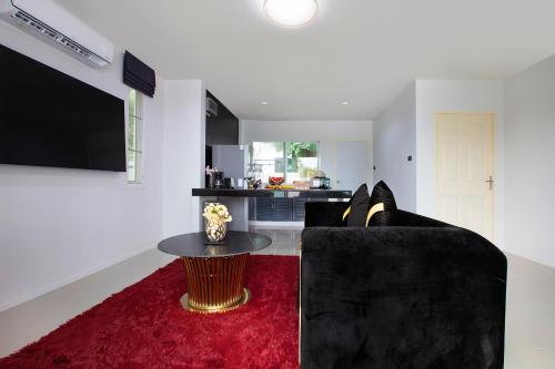 a living room with a black couch and a red rug at Nariya Bayfront Phuket in Ban Bang Chak