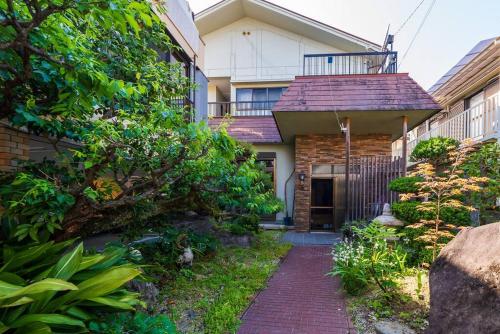 a house with a brick walkway in front of it at 日式庭院古宅难波直达4房双浴室厕所厨房齐全团队首选可体验和服茶道空中瑜伽交通购物方便bbq可 in Izumi-Sano