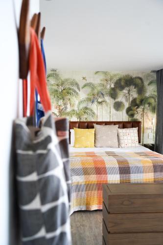 a bedroom with a bed with palm trees on the wall at Atholl House in Cape Town