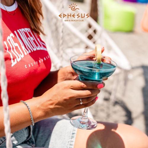 a woman holding a blue drink with a banana in it at Mandarinnart HOTEL in Astara