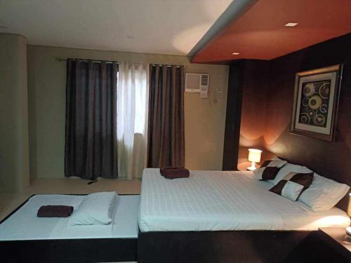 a bedroom with two beds and a window at Casita Isla Beach Inn in Boracay