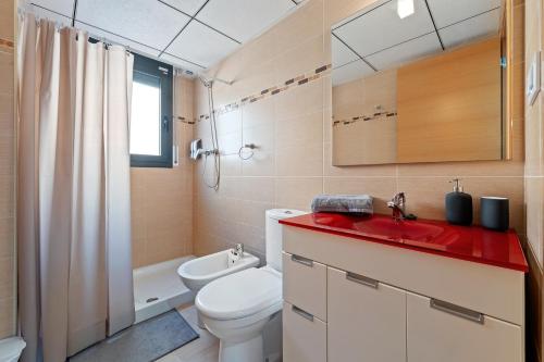 a bathroom with a toilet and a red counter top at Tropikana Paradise Miami in Miami Platja