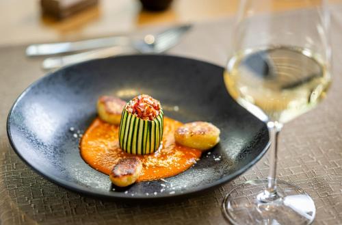 a black plate with a dessert and a glass of wine at Hotel & SPA Reibener-Hof in Konzell