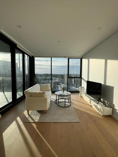 バンクスタウンにあるSydney Private Homeのリビングルーム(白いソファ、テレビ付)