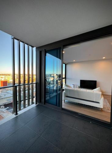 バンクスタウンにあるSydney Private Homeのベッドと大きなガラス窓のあるリビングルーム