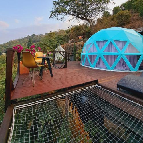 a deck with a tent and a table and chairs at The Luxury Glamping Star in San Gil