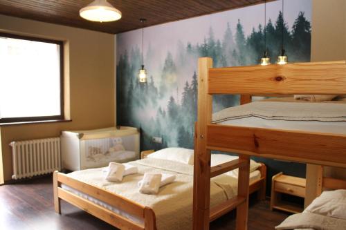 a bedroom with two bunk beds and a painting on the wall at Wellness Villa Totina in Liptovský Mikuláš – Demänová