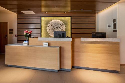 a lobby with two reception desks and a painting at Fairfield Inn & Suites by Marriott Little Rock Airport in Little Rock
